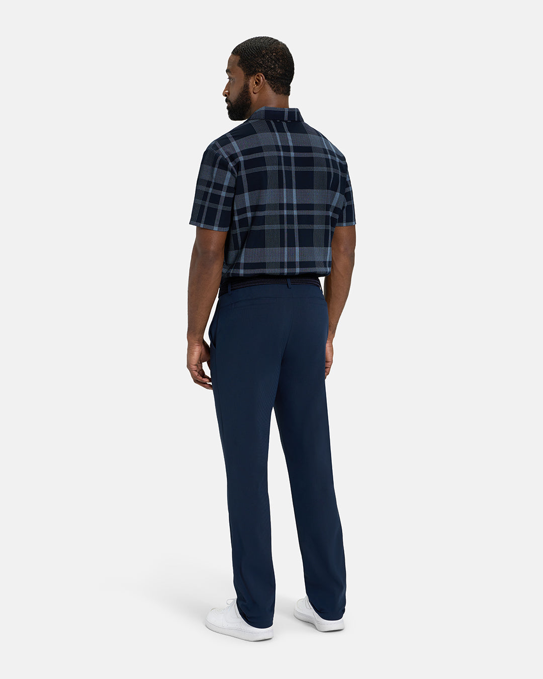 Full Body Back View of Navy Spectator Plaid Polo Tucked on Black Male Model wearing navy pants black belt and white shoes #color_navy