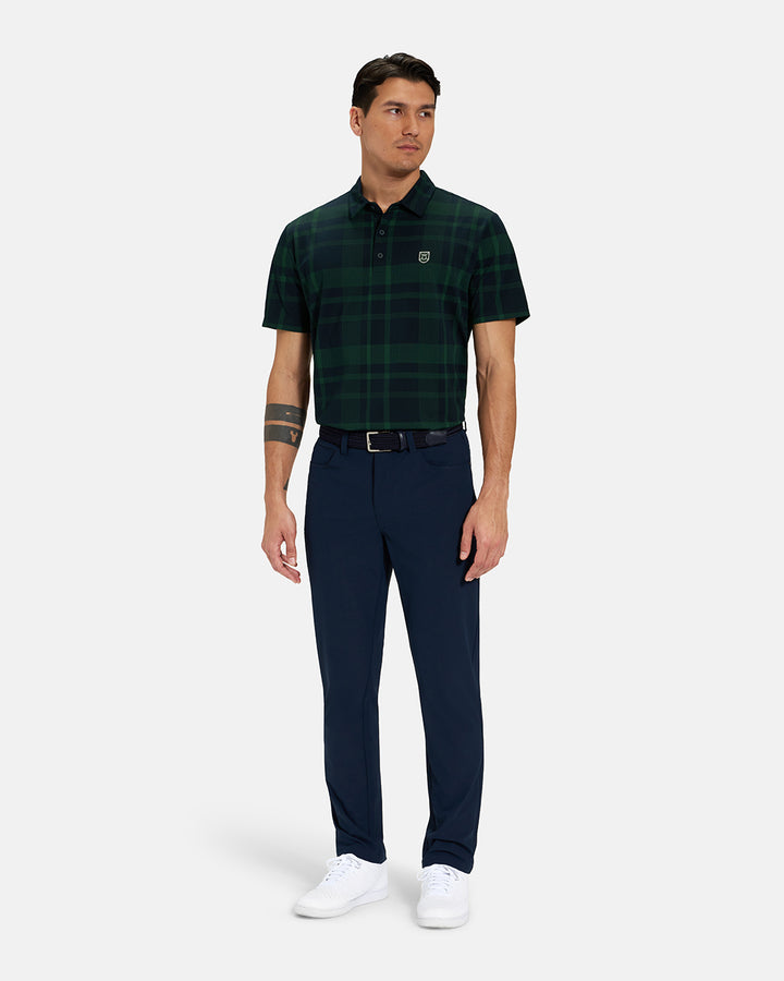 Full Body Front View of Bogey Green Spectator Plaid Polo Tucked on Asian Male Model wearing navy pants black belt and white shoes #color_bogey-green