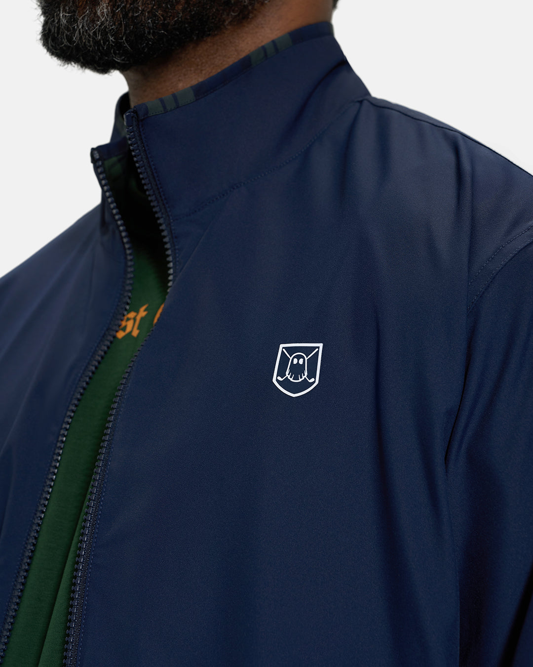 Front Closeup View of Plaid Dark Navy Spectator Reversible Jacket on Black Male Model with Ghost Icon Crest Badge #color_plaid-navy