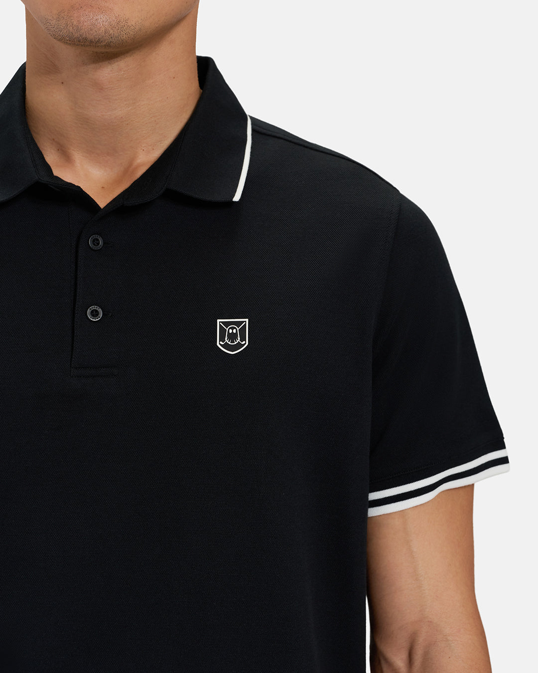 Front Closeup View of Black Spectator Tipped Collar Polo on Asian Male Model with Ghost Icon Crest #color_black