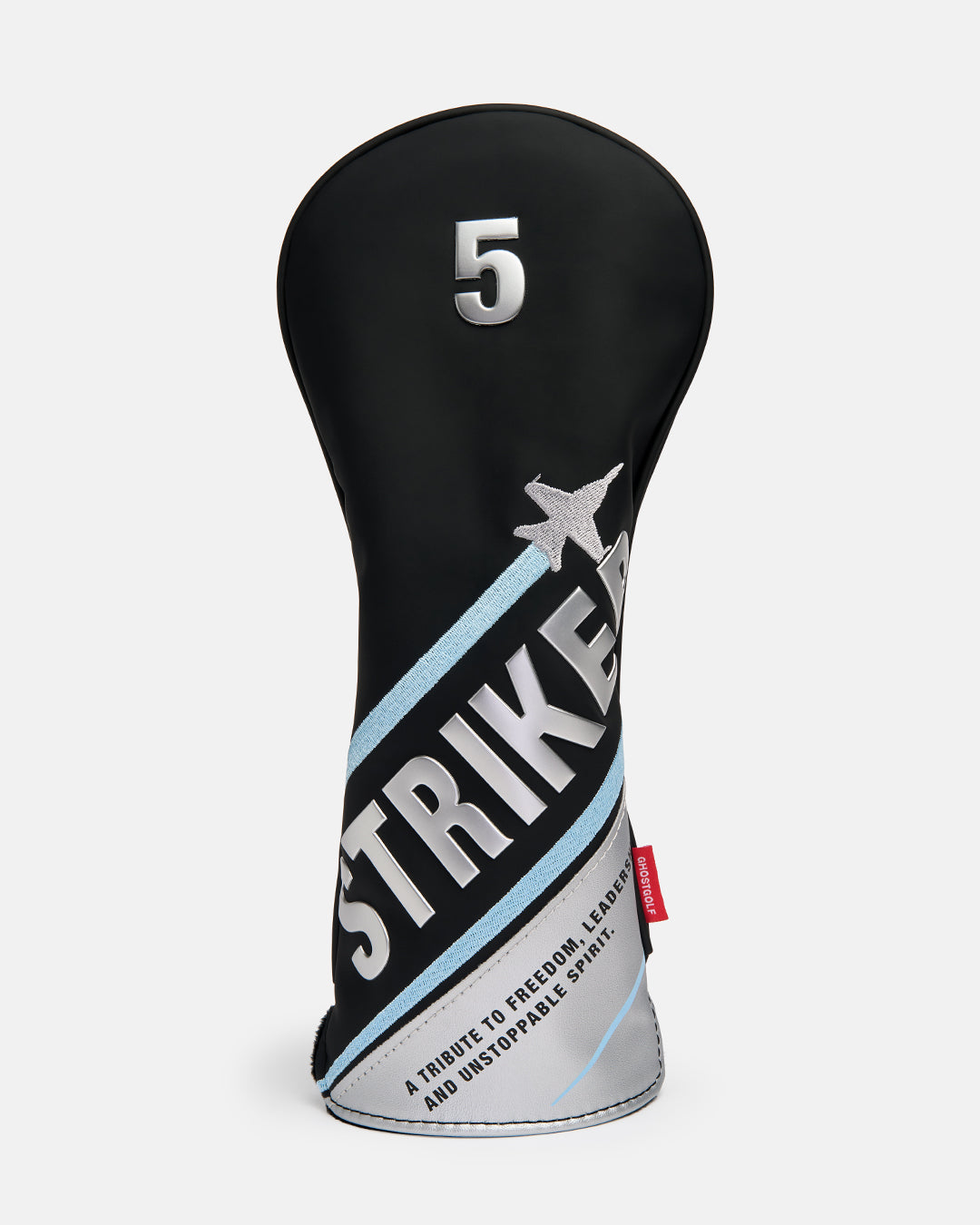 Front product shot of the Striker Tertiary 5 Wood Head Cover featuring oversized Striker typography across the front, with a fighter jet graphic wrapping around the cover. The design also includes a small tribute text detail, showcasing aviation-inspired artwork, premium embroidery. #size_5-wood