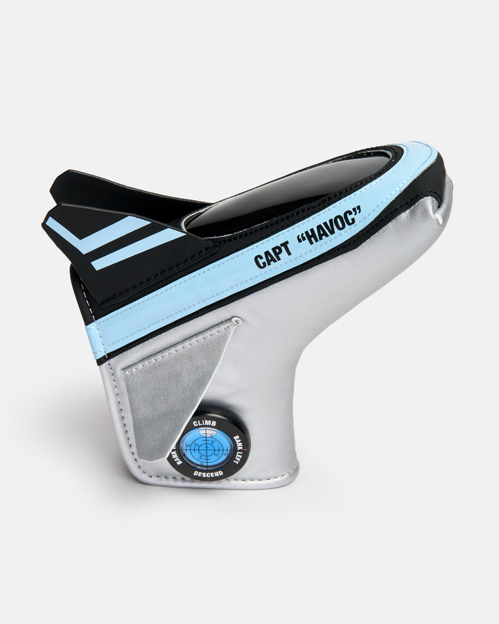 Side product shot of the Striker Blade Putter Cover designed in the shape of a fighter jet, featuring aviation-inspired compass graphics on the side and Capt Havoc typography embroidered across the top. Angled view highlighting the unique aircraft silhouette, premium embroidery, and signature Ghost Golf military-inspired design details.
