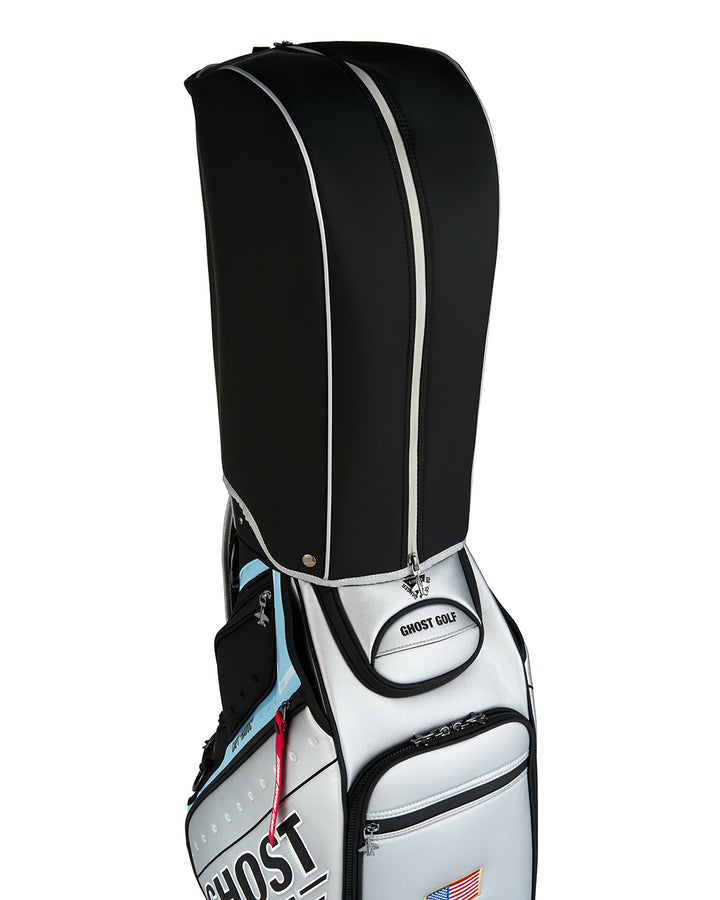 Three-quarter view of the Rain Hood attached to the Striker Staff Bag, showcasing the protective cover design and premium construction.