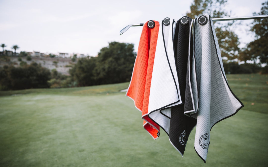 4 Golf Towels stuck on Golf Club with Green Background